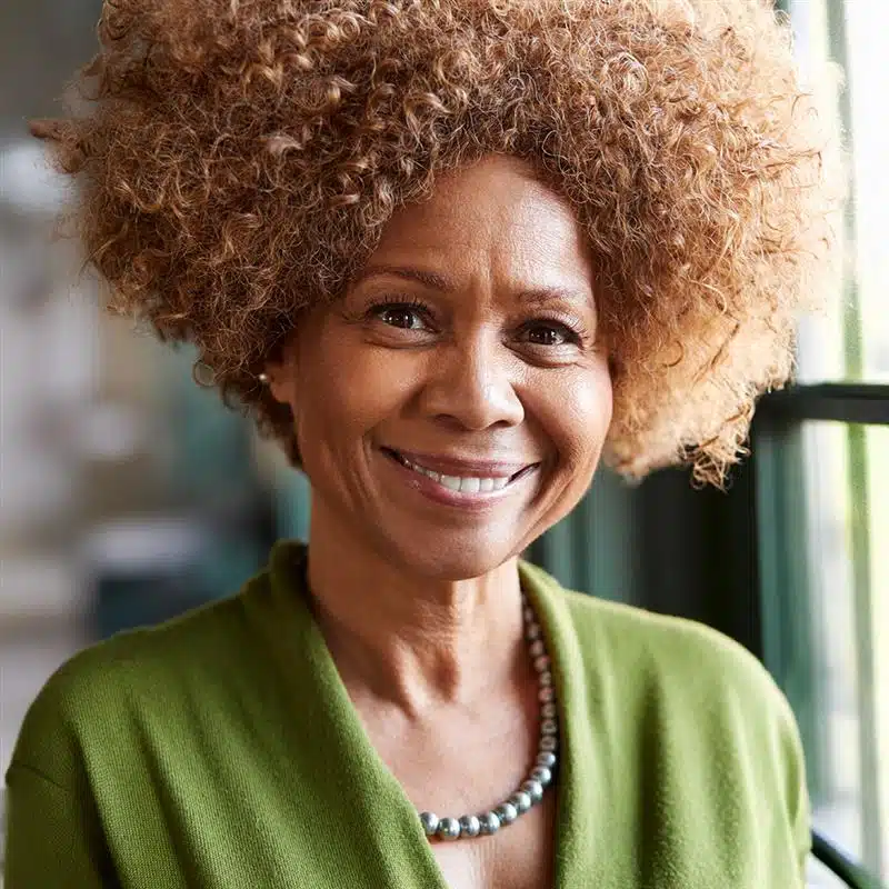 African American woman in green blouse smiling